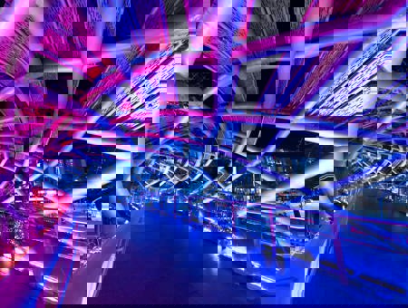 Bridge lit at night with neon pink and purple lighting