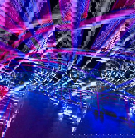 Bridge lit at night with neon pink and purple lighting