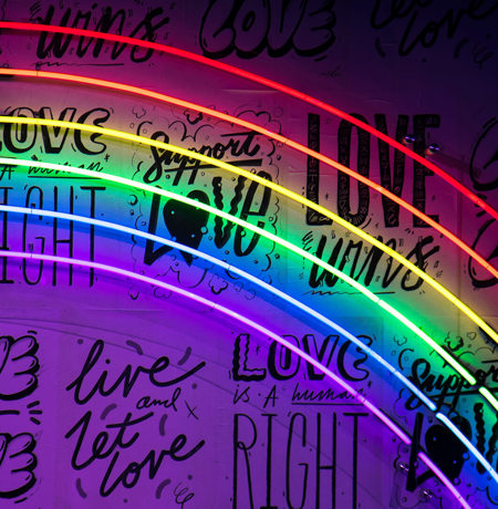 Love wins graffitti wall with neon rainbow