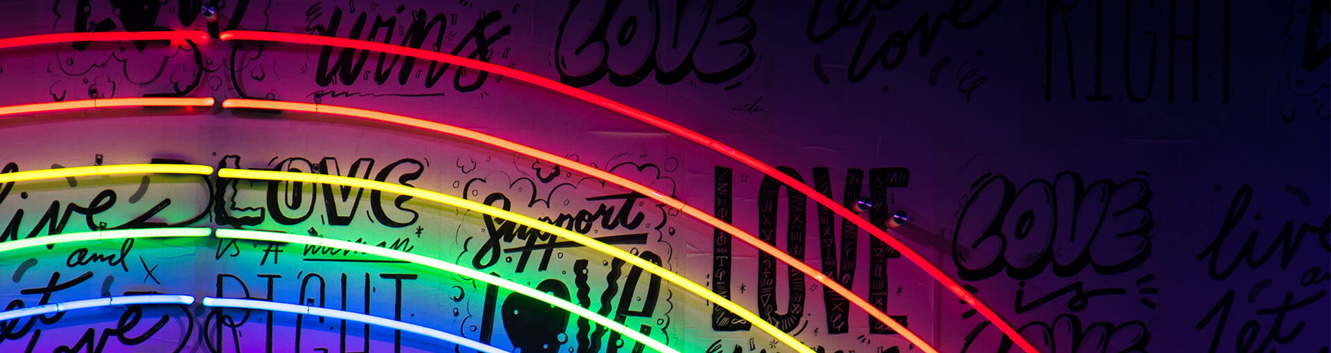 Love wins graffitti wall with neon rainbow