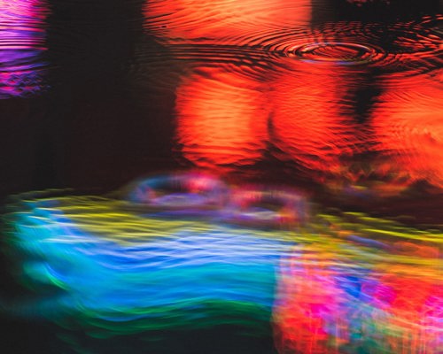Neon light reflections in puddle