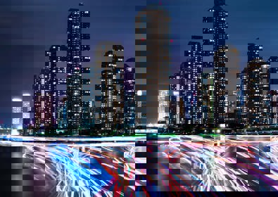 City at night with neon car trails 