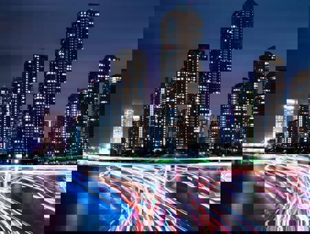 City at night with neon car trails 