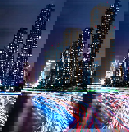 City at night with neon car trails 