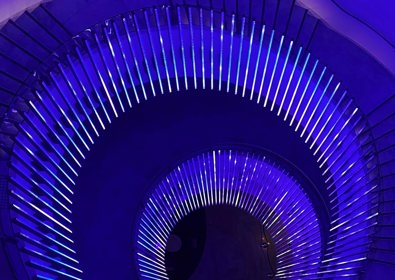 View of spiral staircase in neon blue lighting