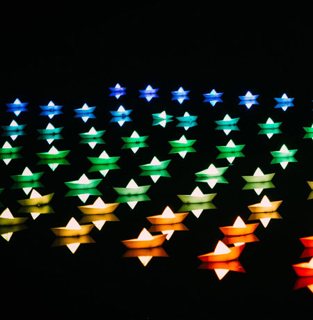 Image of neon stars in blue, green and red on a black background