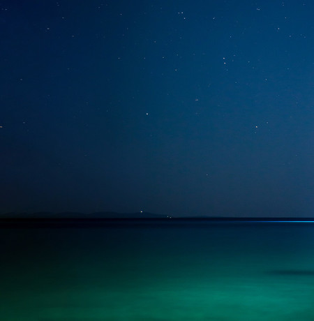 Image of sailing boat on calm sea at night