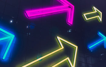 Neon arrows on the side of a building in multiple colours