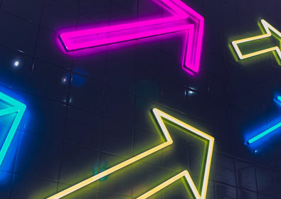 Neon arrows on the side of a building in multiple colours