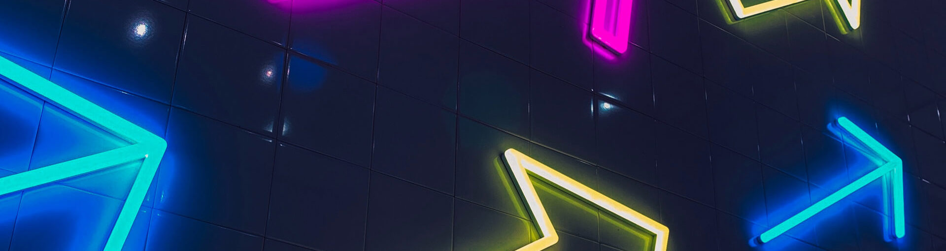 Neon arrows on the side of a building in multiple colours