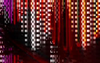 Bright orange vertical neon lights along a body of water