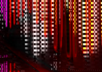 Bright orange vertical neon lights along a body of water