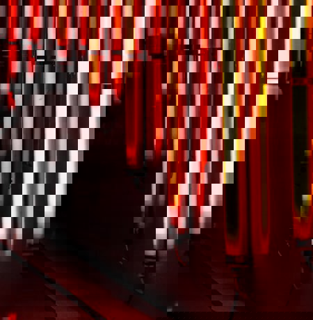 Bright orange vertical neon lights along a body of water