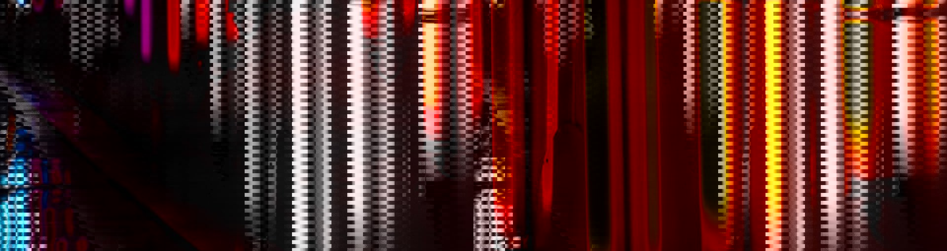 Bright orange vertical neon lights along a body of water