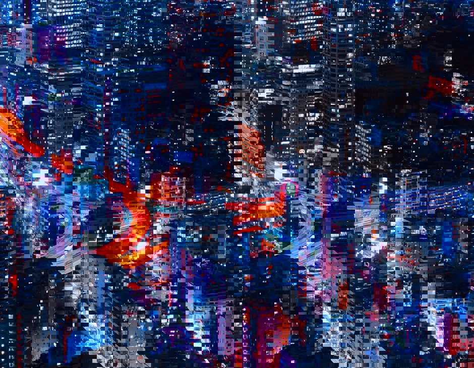 Nightime view of city with neon orange lighting up the roads