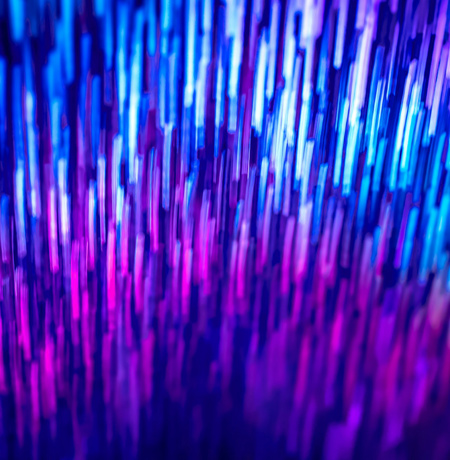 Abstract image of neon lights shooting up vertically in blue and purple