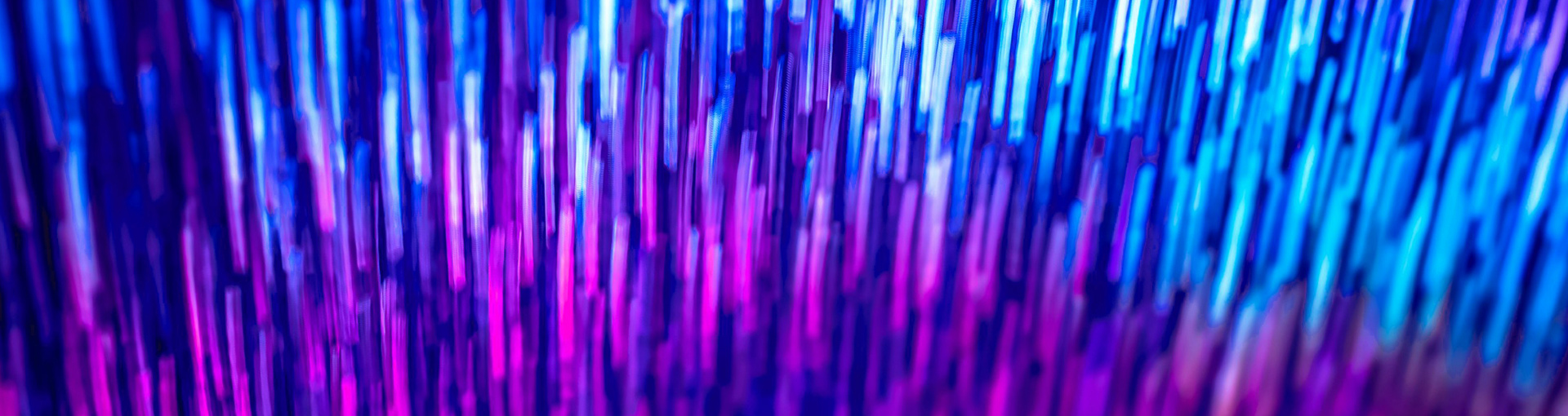 Abstract image of neon lights shooting up vertically in blue and purple
