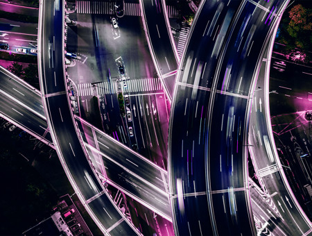 Image of motorway intersection at night lit up with pink lights
