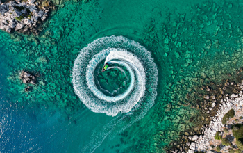 Birds eye view of a speed boat on the water in a green calm sea