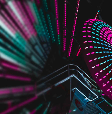 Image from ground looking up at large neon ferris wheel